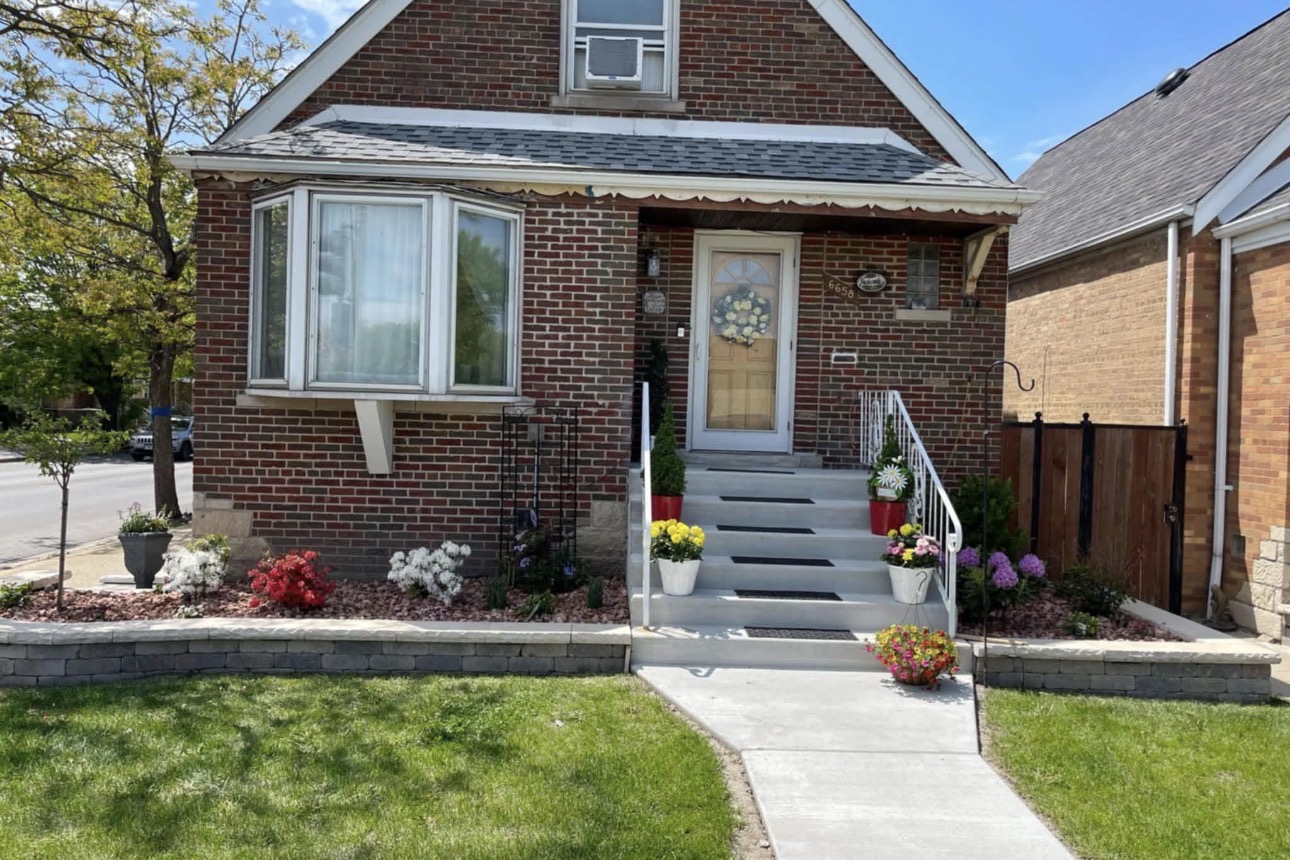 Residential front yard with new stone retaining wall, flower beds and finished steps